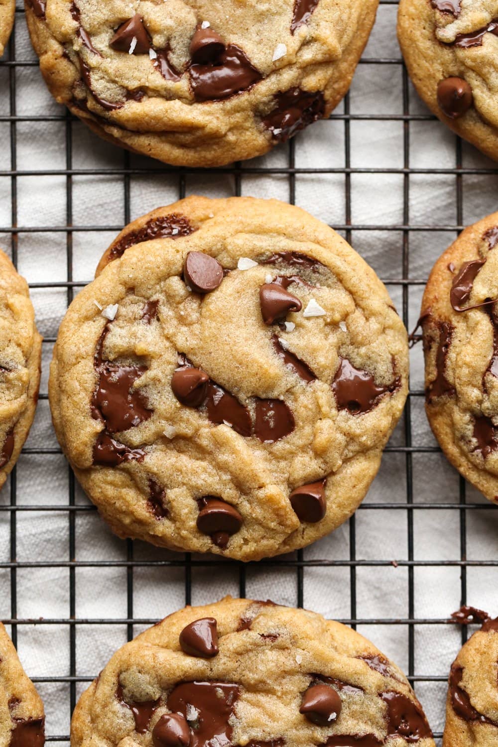 Chocolate chip cookie from above on a cooling rack with flaked sea salt