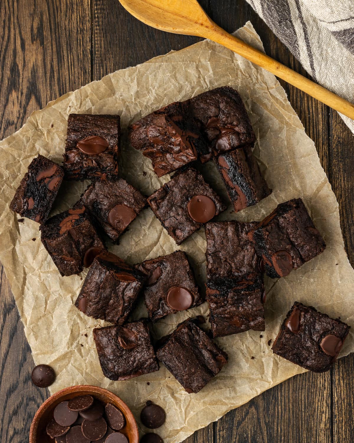 Overhead view of assorted cake mix brownies scattered over a sheet of parchment paper.