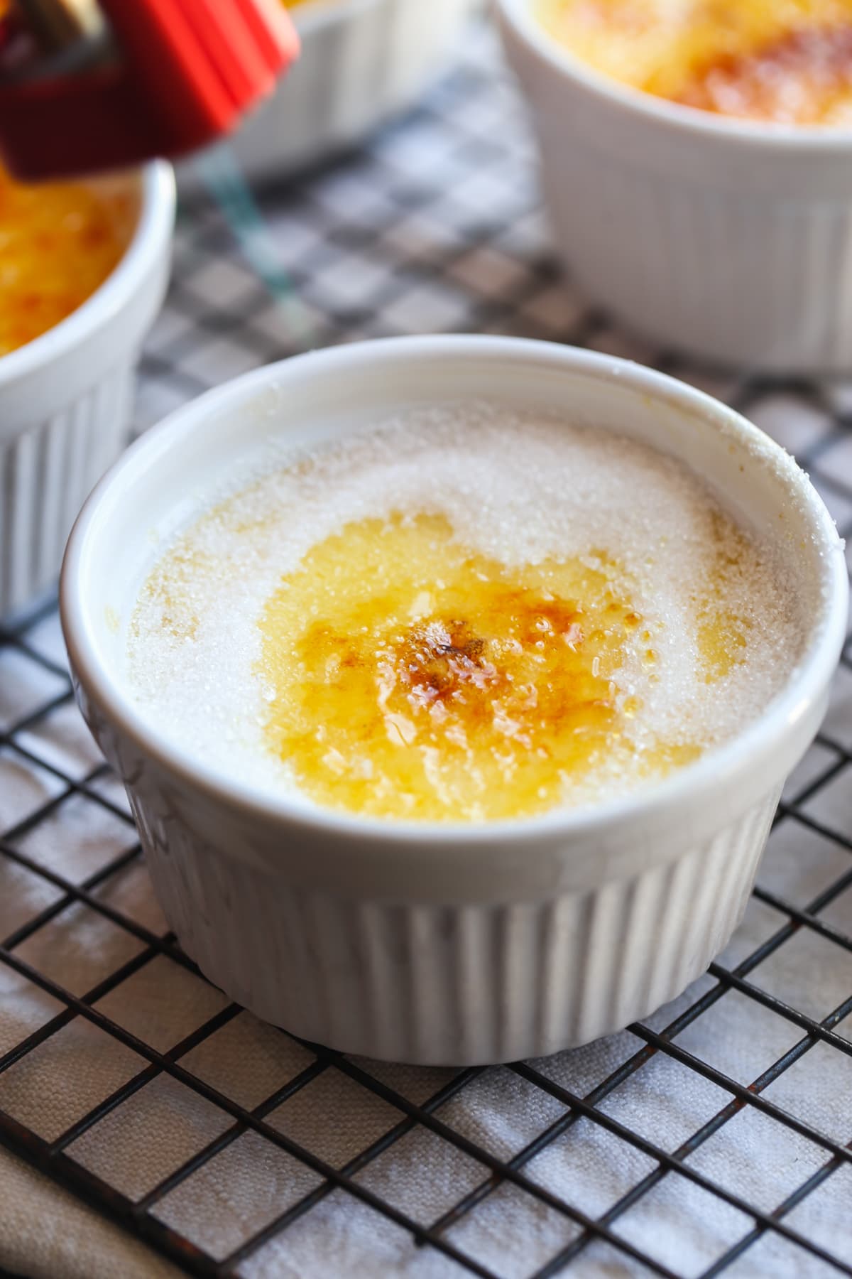 Torching sugar on top of custard baked in a white ramekin