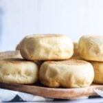 Homemade English muffins stacked on a plate