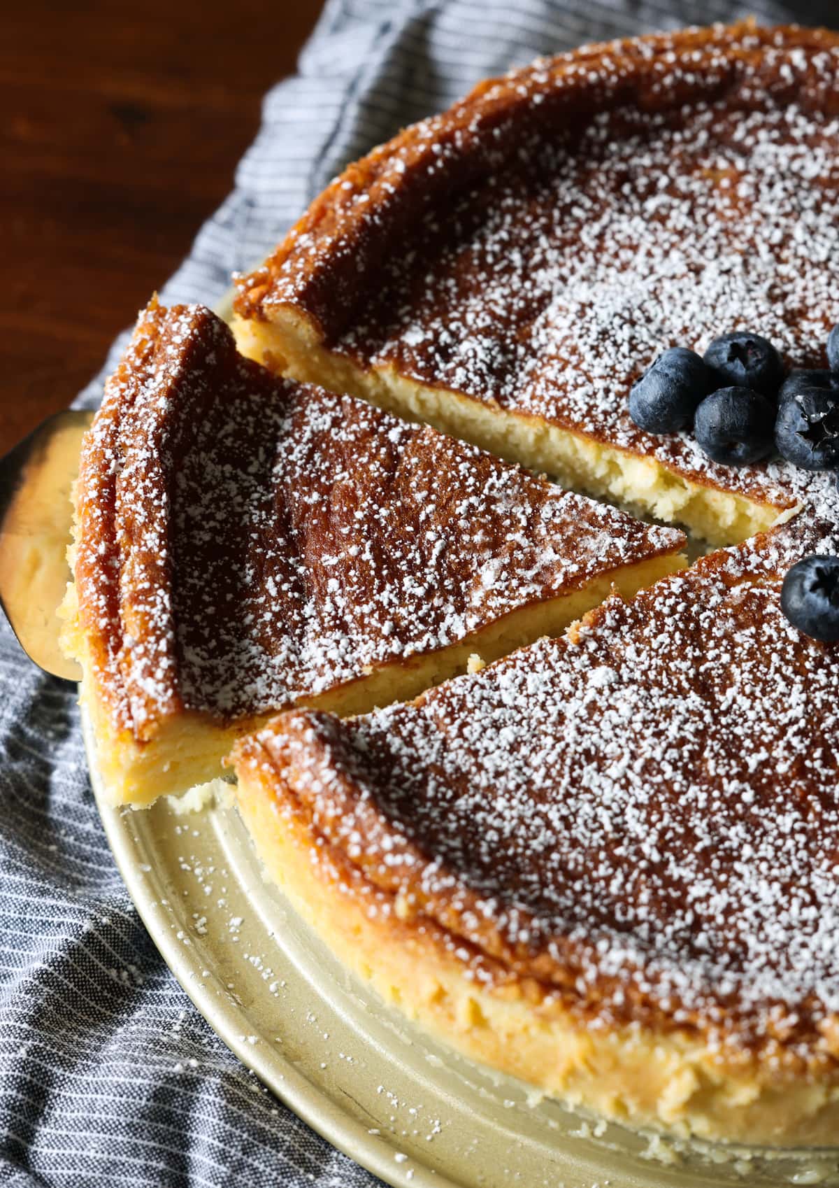 Overhead view of a slice being cut and lifted from a flourless white chocolate cake.