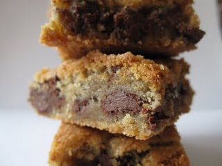 A stack of chocolate chip cookie bars on a white surface.