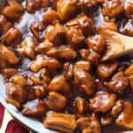 Bourbon Chicken in a skillet garnished with chives