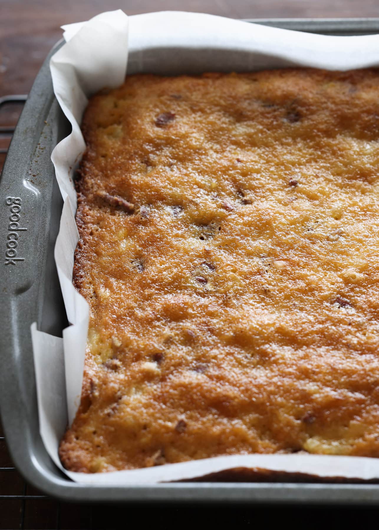 Baked cake in a 9x13 pan lined with parchment paper