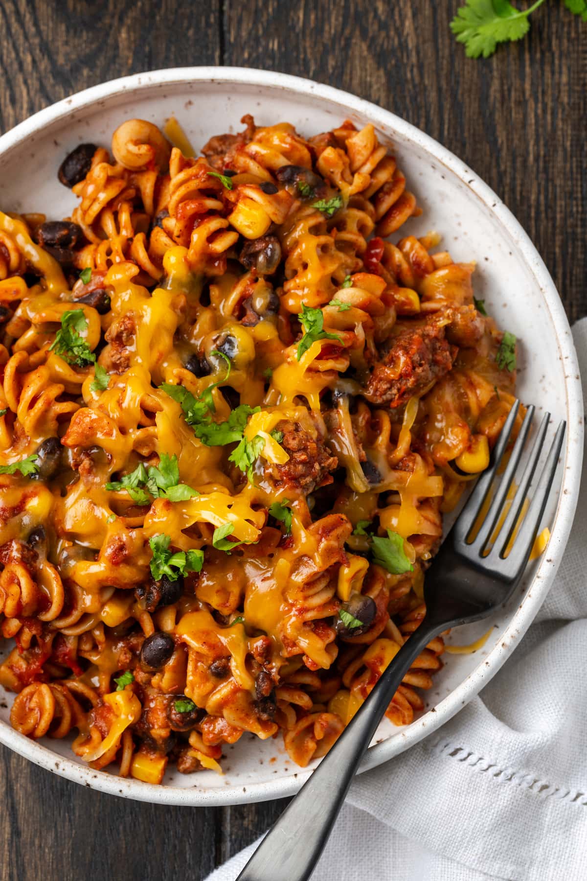 Overhead view of taco pasta in a white bowl with a fork.